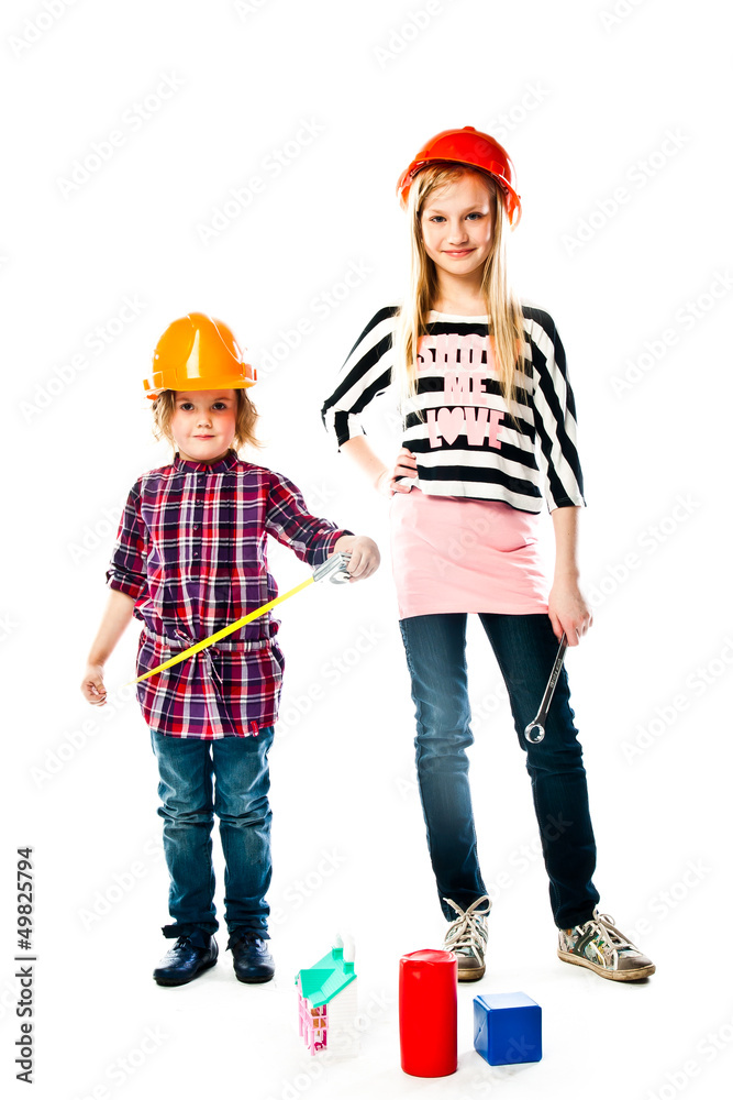 Two young beautiful girls in building helmet and tools in hand Two young beautiful girls in building helmet and tools in hand