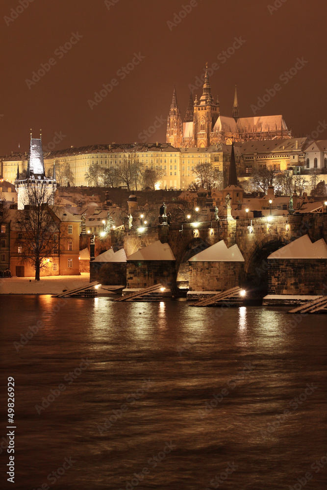 Night colorful snowy Prague gothic Castle with Charles Bridge
