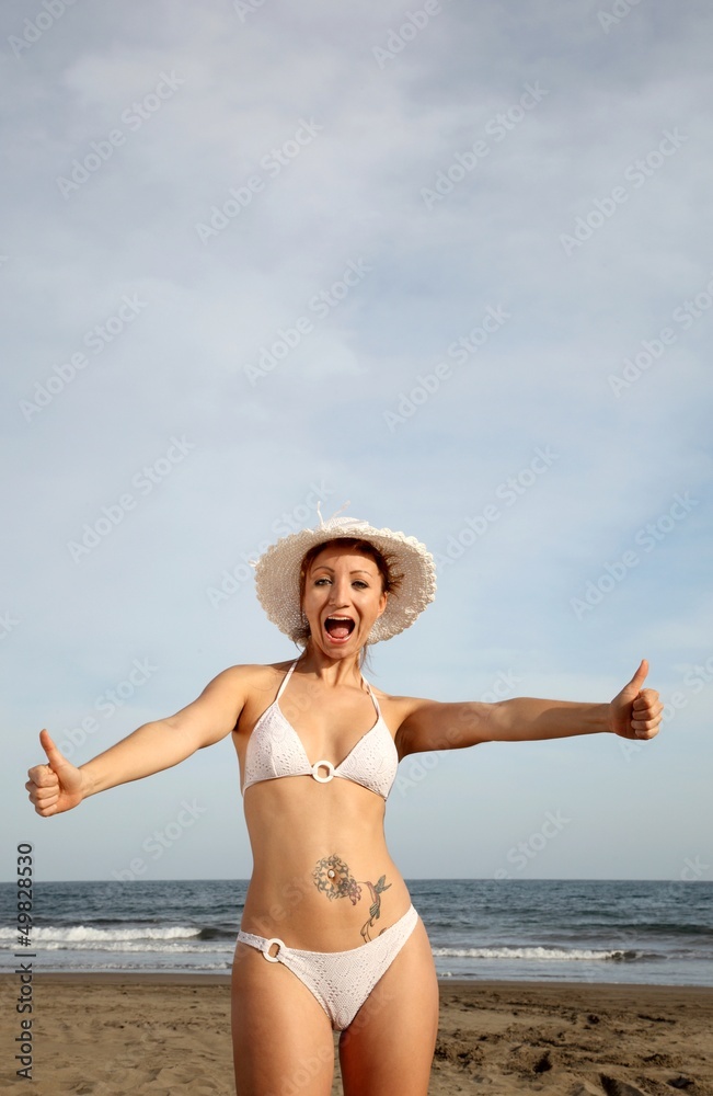 woman at the beach in bikini with thumbs up