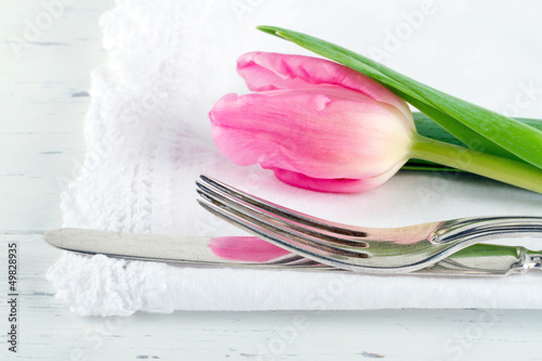 Closeup of pink tulip at rustic dinner setting