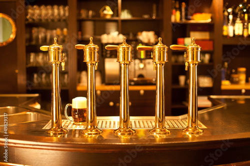 Φωτογραφία Luxury gold beer spigot at the brewery with a glass of beer