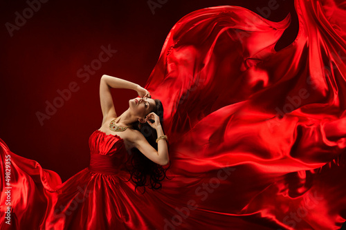 Woman in red dress blowing with flying fabric