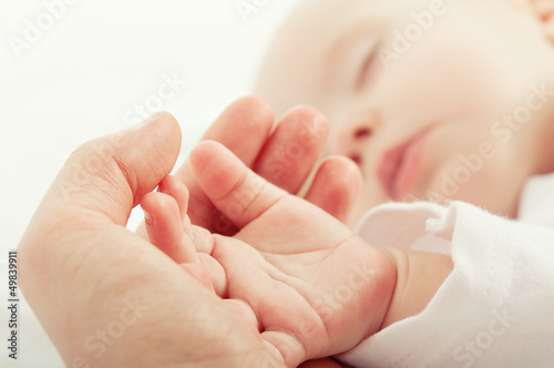hand the sleeping baby in the hand of mother