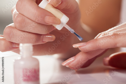 girl cleans her nails with a cotton swab