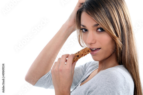 young woman eating a cereal bar