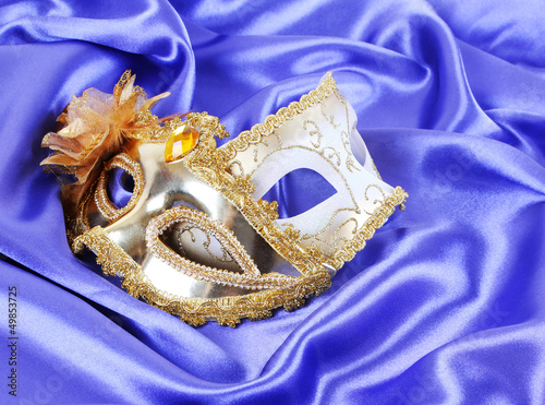 gold carnival masks on blue silk fabric