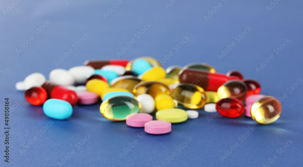 Assortment of pills, tablets and capsules on blue background Assortment of pills, tablets and capsules on blue background