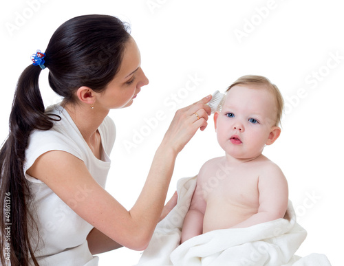 mother is combing baby s hair after bathing