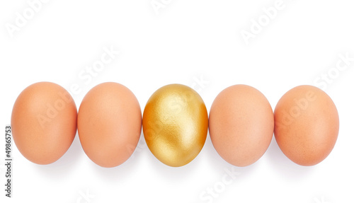 Chicken eggs in a row and in the middle a golden Easter.
