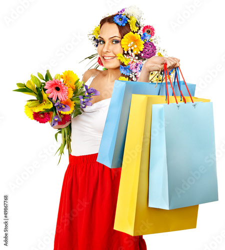 Woman with shopping bag holding flower.