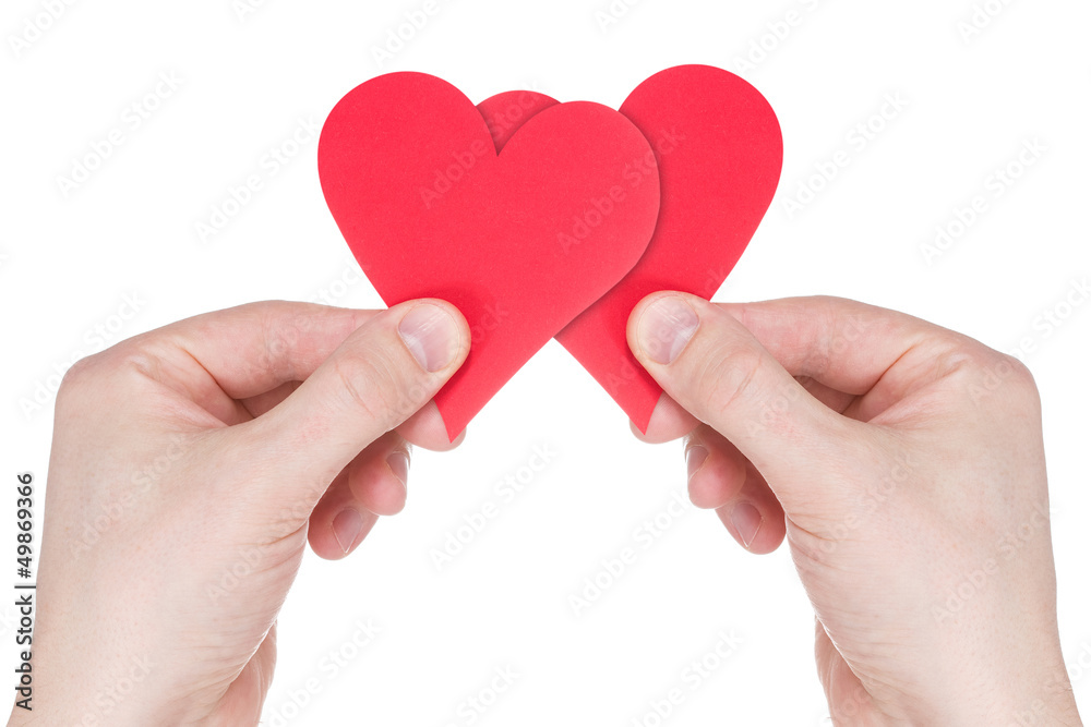 Obraz premium Hands holding two red paper hearts