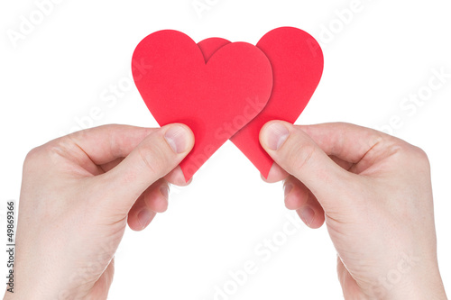 Hands holding two red paper hearts
