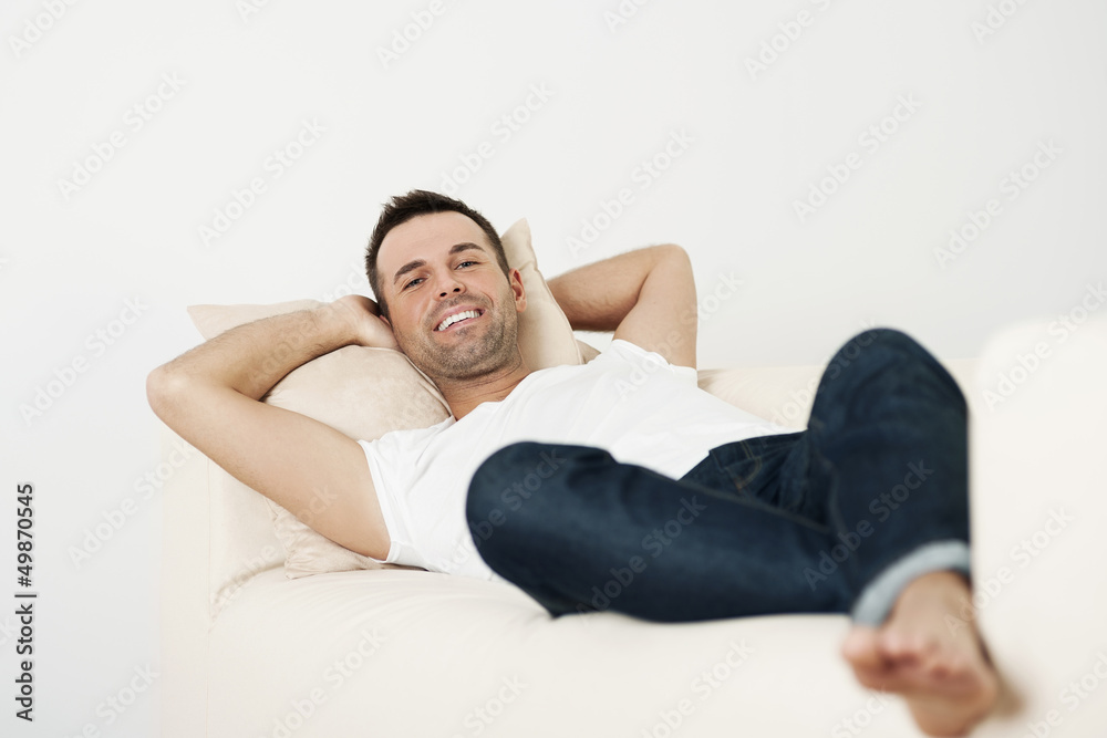 Happy male relaxing on couch at home