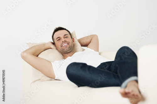 Happy male relaxing on couch at home