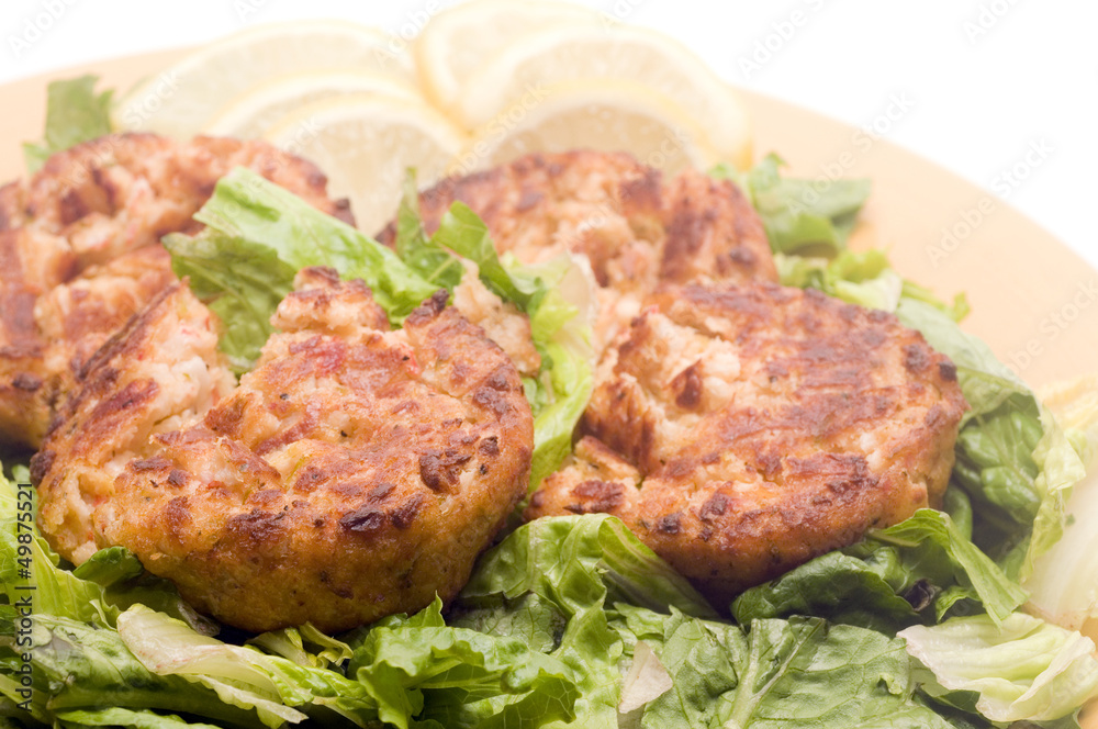 lobster cakes bed of lettuce with lemon slice wedges lobster cakes bed of lettuce with lemon slice wedges