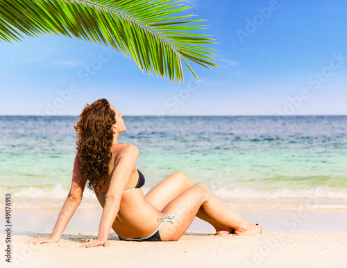 woman is sitting on beach © Sergey Peterman