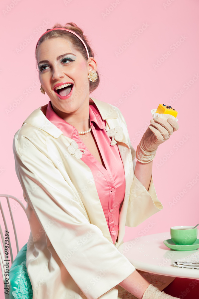 Girl blonde hair fifties fashion style eating cup cake. Girl blonde hair fifties fashion style eating cup cake.
