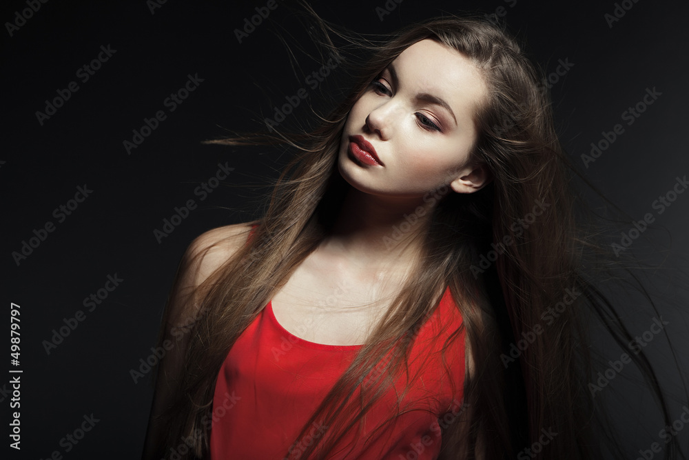 Portrait of a beautiful young woman in a red dress. Portrait of a beautiful young woman in a red dress.