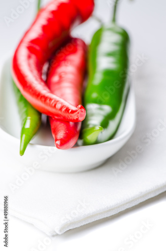 Green and red chili peppers in bowl