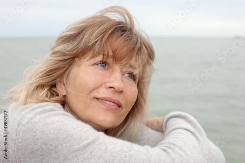 Schilderij op canvas close up portrait of mature woman daydreaming outdoors