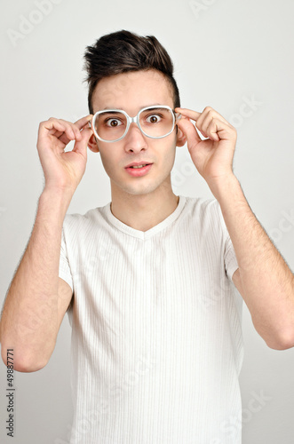 Surprised  amazed  confused.Young man with funny glasses.