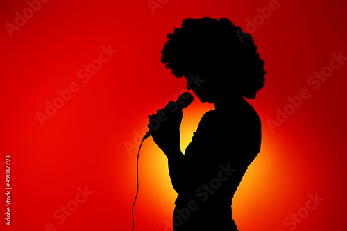 Silhouette of singing woman with microphone
