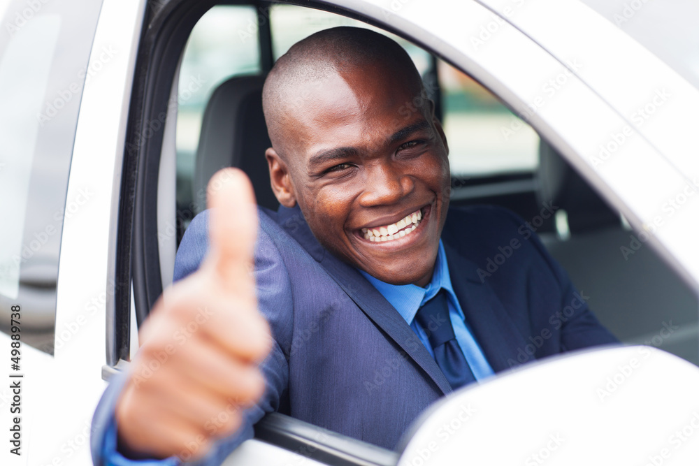 happy african businessman giving thumb up inside new car