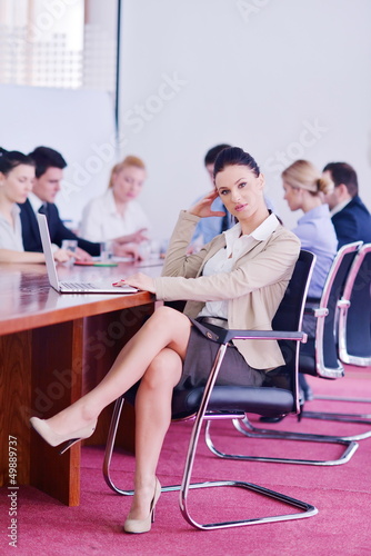 business woman with her staff in background at office