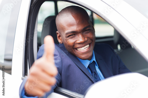 happy african businessman giving thumb up inside new car © michaeljung