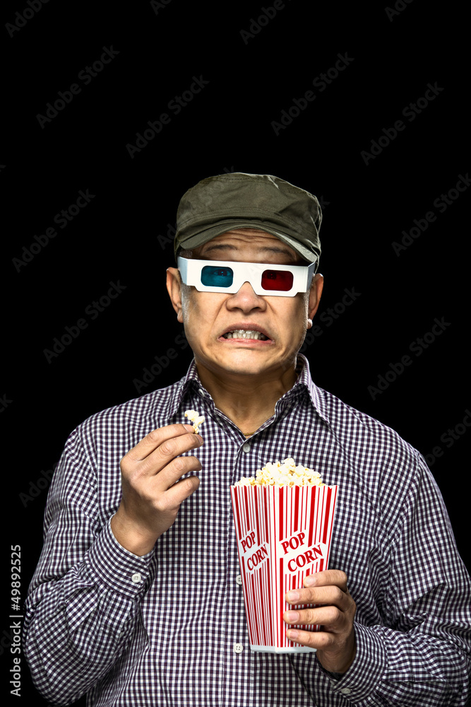 Fototapeta premium Cringing with fear while watching a movie