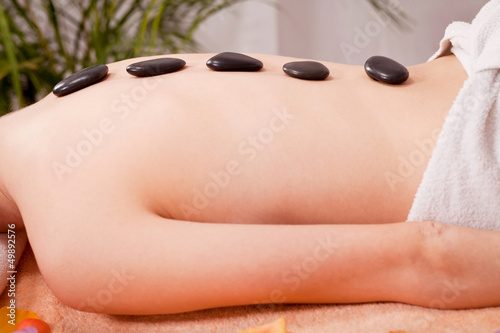 junge attraktve frau bekommt eine hot stone massage