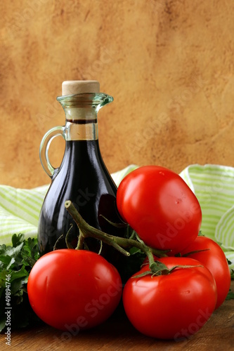 bottle of balsamic vinegar and fresh tomatoes photo