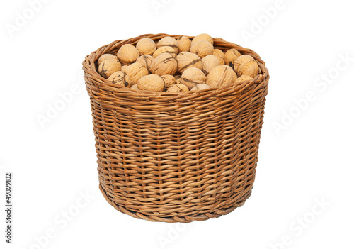 Walnuts in wicker basket isolated on white background
