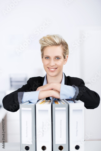 frau im büro stützt sich auf aktenordner photo