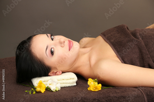 Beautiful young woman in spa salon, on dark background