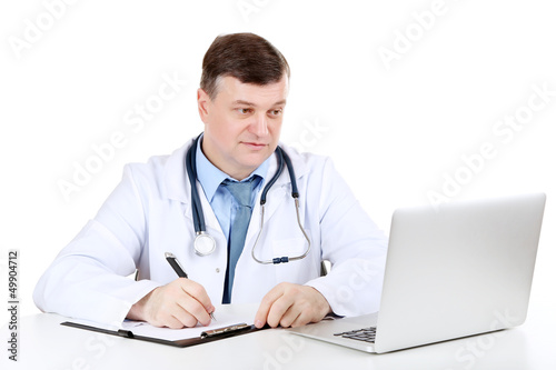 Medical doctor working at desk isolated on white