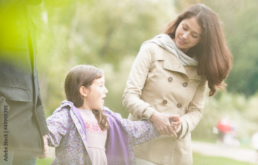 Fototapeta premium Young happy family of three walking outdoor.