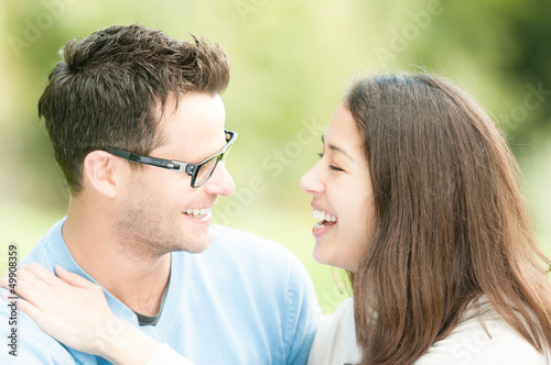 Portrait of happy young man and woman in park. © Konstantin Yolshin