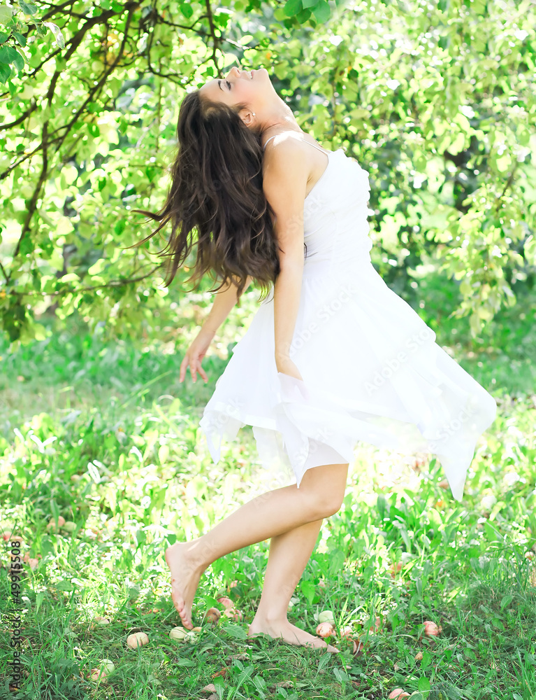 Beautiful young woman dancing in the morning bright summer orcha Beautiful young woman dancing in the morning bright summer orcha