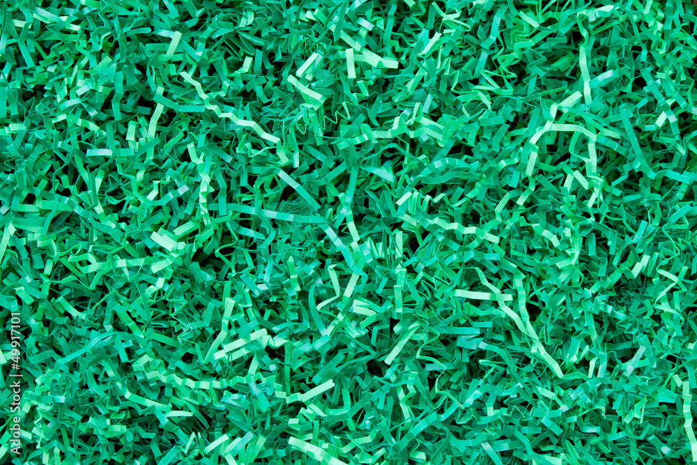Close-up of green shredded paper packaging material background Close-up of green shredded paper packaging material background