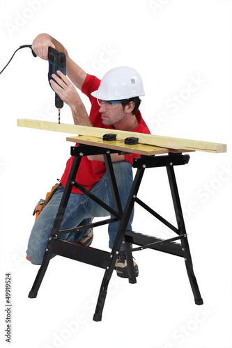 Handyman drilling a piece of wood. photo