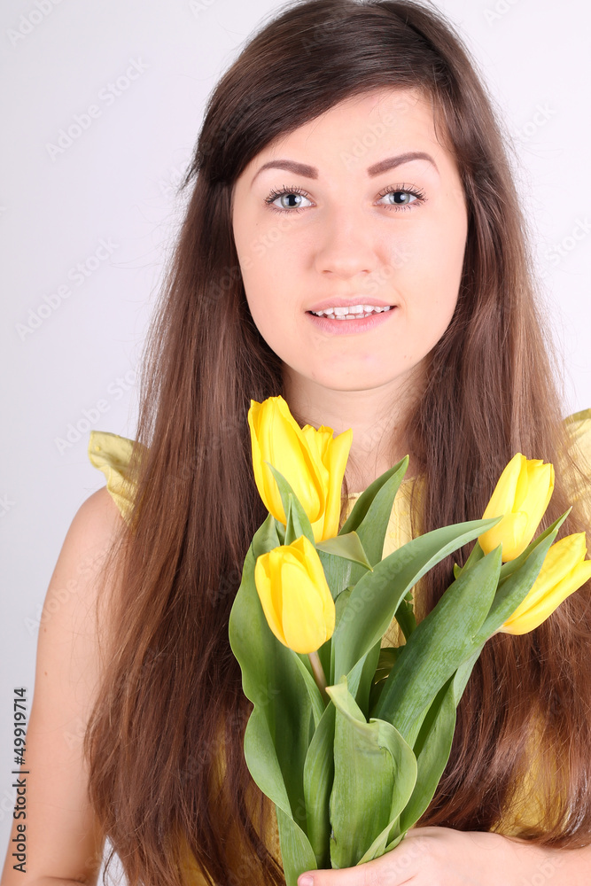 Beautiful long-haired romantic girl with yellow tulips Beautiful long-haired romantic girl with yellow tulips