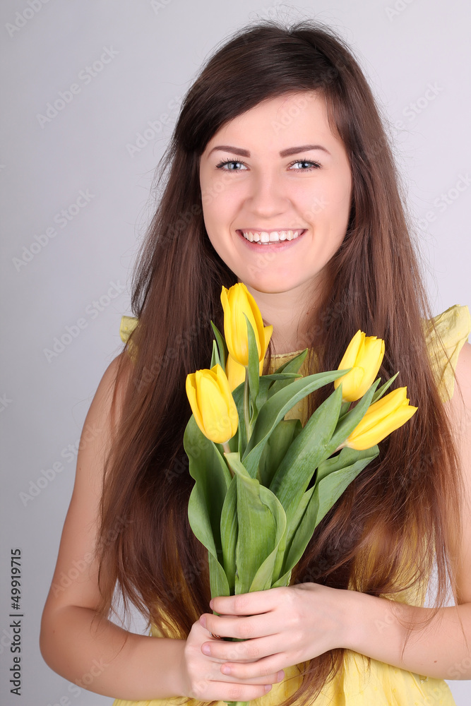 Beautiful long-haired romantic girl with yellow tulips Beautiful long-haired romantic girl with yellow tulips