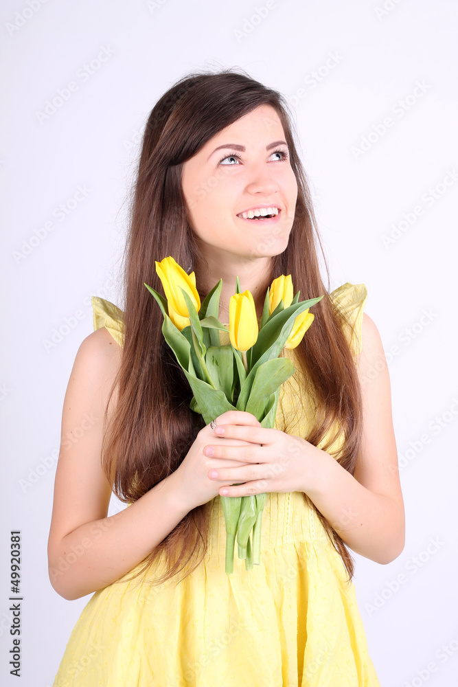 Beautiful long-haired romantic girl with yellow tulips Beautiful long-haired romantic girl with yellow tulips