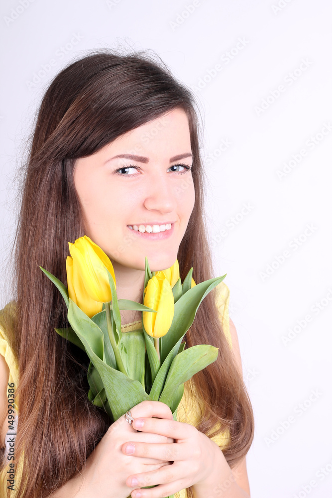 Beautiful long-haired romantic girl with yellow tulips Beautiful long-haired romantic girl with yellow tulips