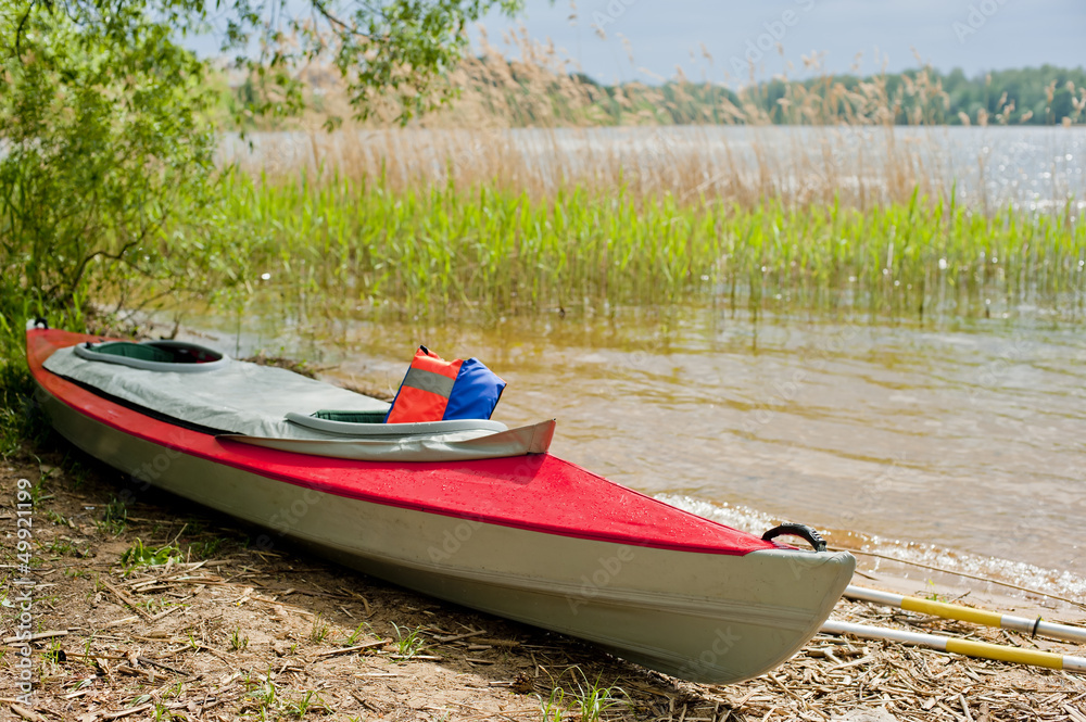 folding red canoe on the shore of Lake