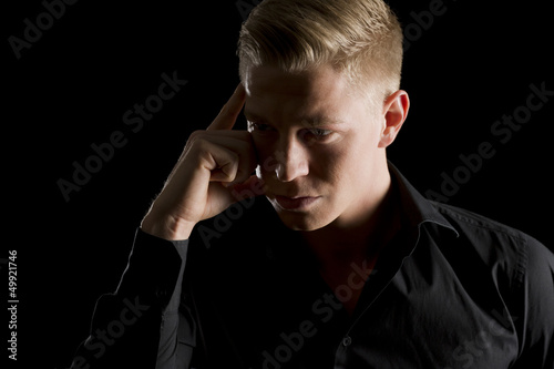Tableau sur toile Low key portrait of attractive man looking aside.