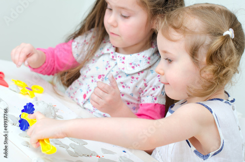 Two little girls sculpting using clay