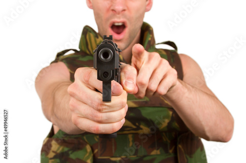 Soldier in camouflage vest is holding a gun