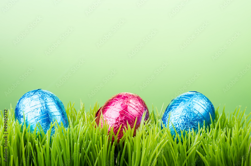 Three chocolate foil Easter eggs on grass